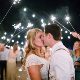 Tahoe Wedding Planners couple kissing under sparkler arch at private Incline wedding venue on Lake Tahoe, Joy of Life Events image by Elena​ Graham Photography