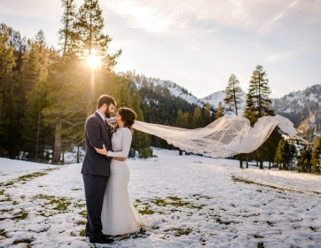 Joyful Lake Tahoe Wedding Planners couple in snow with brides veil in air, winter wedding at venue The Resort at Squaw Creek, Lake Tahoe, Joy of Life Events image by Charleston Churchill